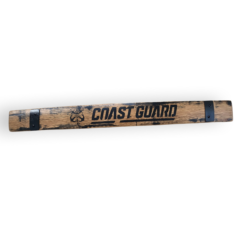 A weathered wooden oar crafted from reclaimed oak barrel staves, featuring "COAST GUARD" and an anchor symbol painted in black.