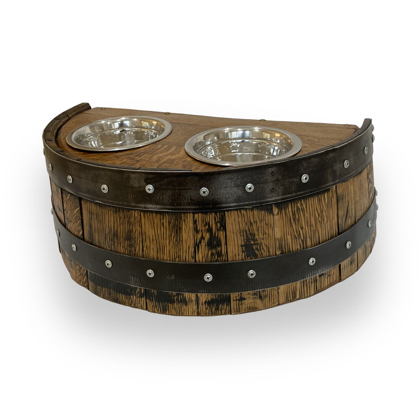 The Whiskey Barrel Pet Feeder features a half-barrel design with two stainless steel bowls on top, accented by black metal bands for a stylish and functional look for your pets.