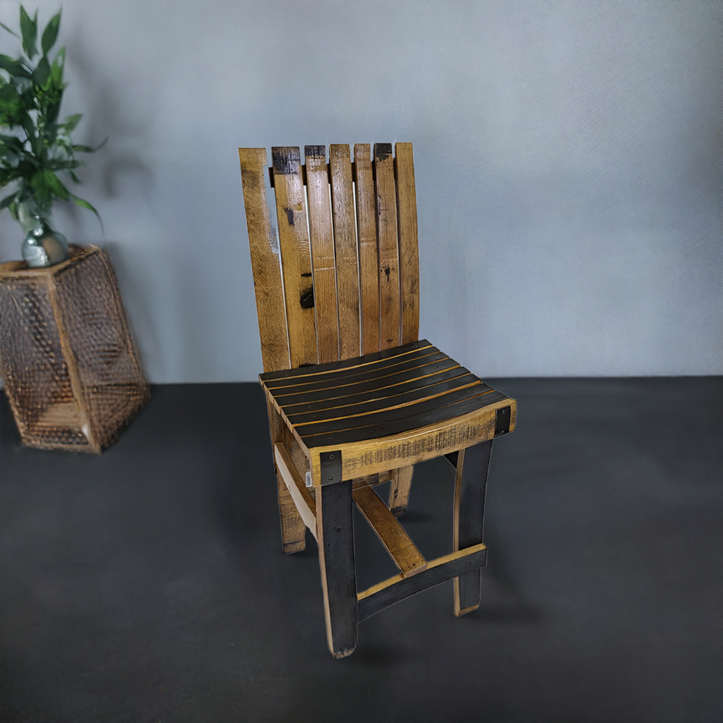 A handmade Dining Chair features solid wood barrel stave construction, a compact slatted backrest and seat, shown on a dark floor beside a small table with a plant.