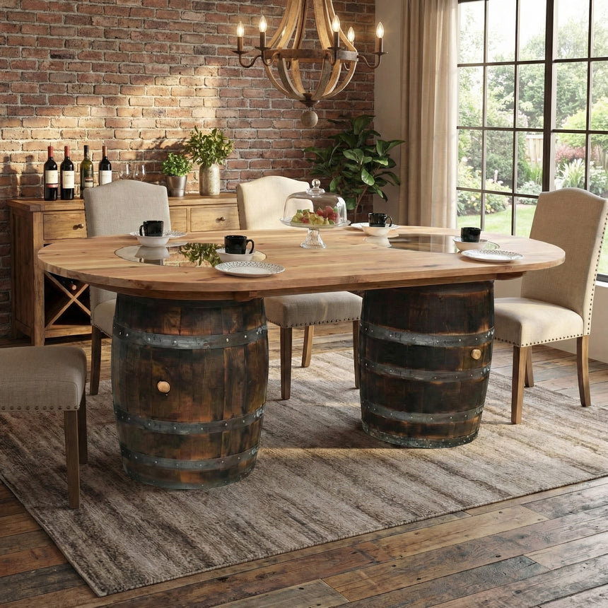 The Double Barrel Table features barrels as legs in a rustic setting with brick walls, a large window, and elegant chairs—a handcrafted piece ideal for anyone seeking unique barrel furniture.