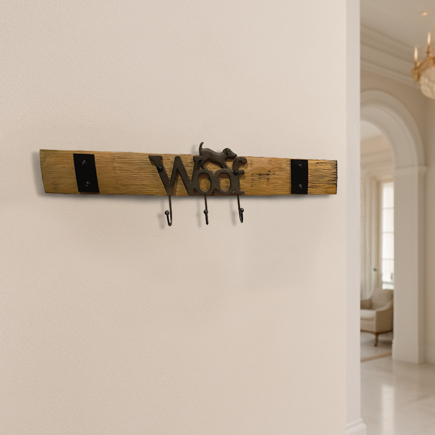 The Leash Holder is handmade from whiskey barrel staves, featuring “Woof” and a dog figure—a stylish wall hook perfect for leashes in any bright, elegant home.