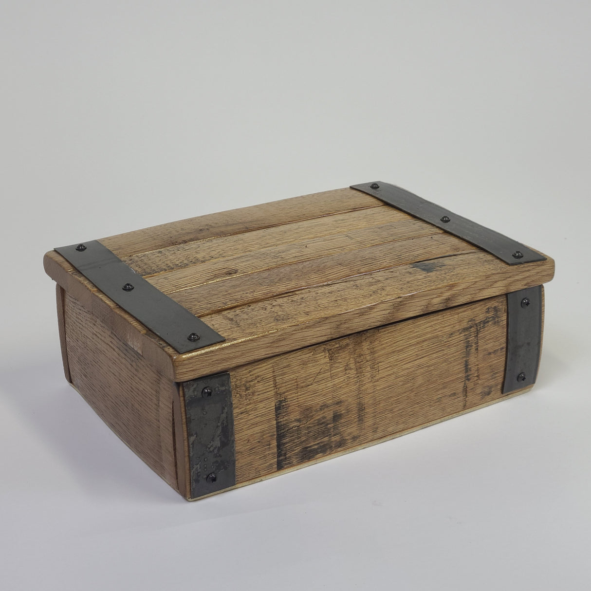 A closed Small Stave Box - A009, a vintage wooden chest with metal reinforcements on the corners and edges, set against a plain background, showcasing premium quality craftsmanship.