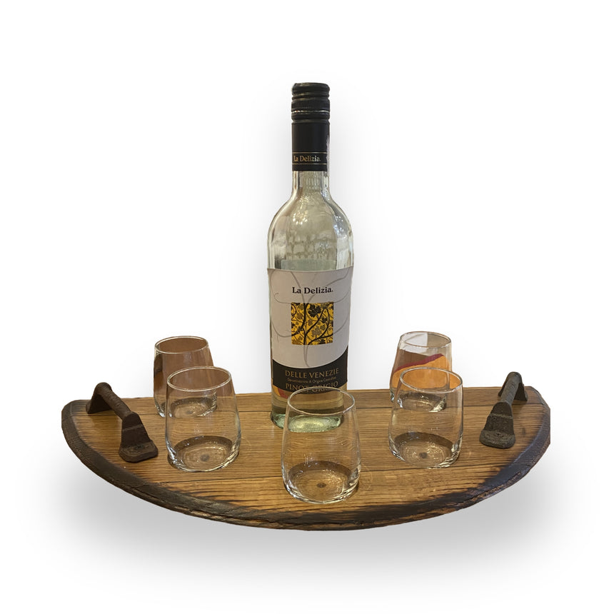 The Wine Tasting Tray showcases a wine bottle and four glasses on a handcrafted barrel-head tray, each paired with a small utensil for a touch of rustic elegance.