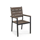 The Outdoor Chair features wooden slats, armrests, and a black metal frame on a white background, blending modern functionality and timeless style.