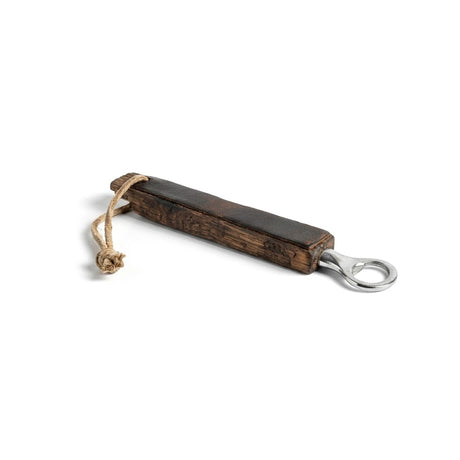 The Bottle Opener, made from whiskey barrel staves with a wooden handle and looped string, is displayed on a white surface.