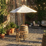 A patio with potted plants, a Patio Pub Table, a stool, and an umbrella set under string lights.