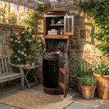 A Barrel Vanity with shelves stands in a garden patio, surrounded by flowers and potted plants.