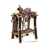 A brown leather horse saddle sits on the Saddle Stand, with reins neatly draped on the side.