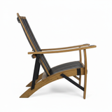 Side view of the Adirondack Lounge Chair, Hand Made Solid Wood Barrel Stave Construction, featuring black slats and curved armrests, crafted from reclaimed whiskey barrel staves against a white background.