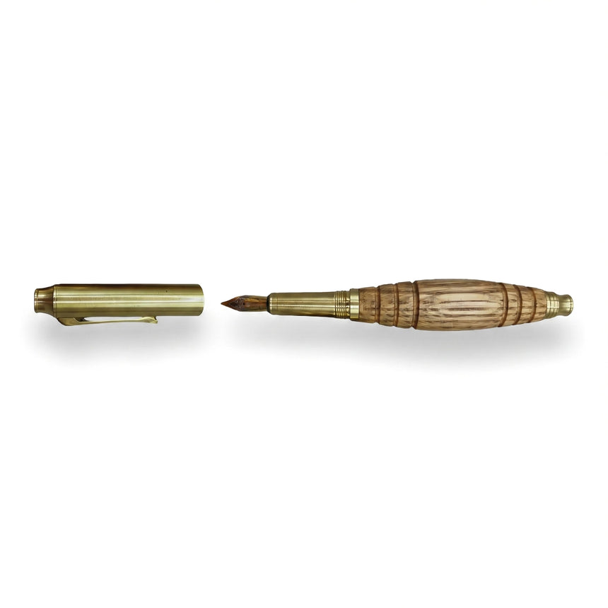 The Bourbon Barrel Fountain Pen, handcrafted from reclaimed Kentucky bourbon barrels, is shown on a white background with its gold cap removed and placed beside it.