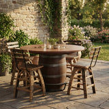 The Barrel Bar Table And Stool with Back, set outdoors on a stone patio surrounded by garden plants, creates a charming and inviting space for relaxing or entertaining.
