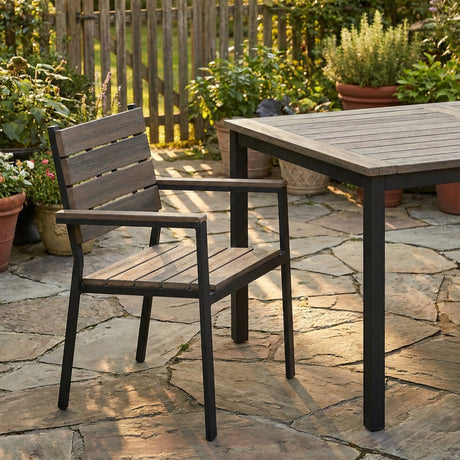 Outdoor Chair placed beside a matching table on a stone patio, surrounded by potted plants and greenery, combining modern functionality with classic charm.