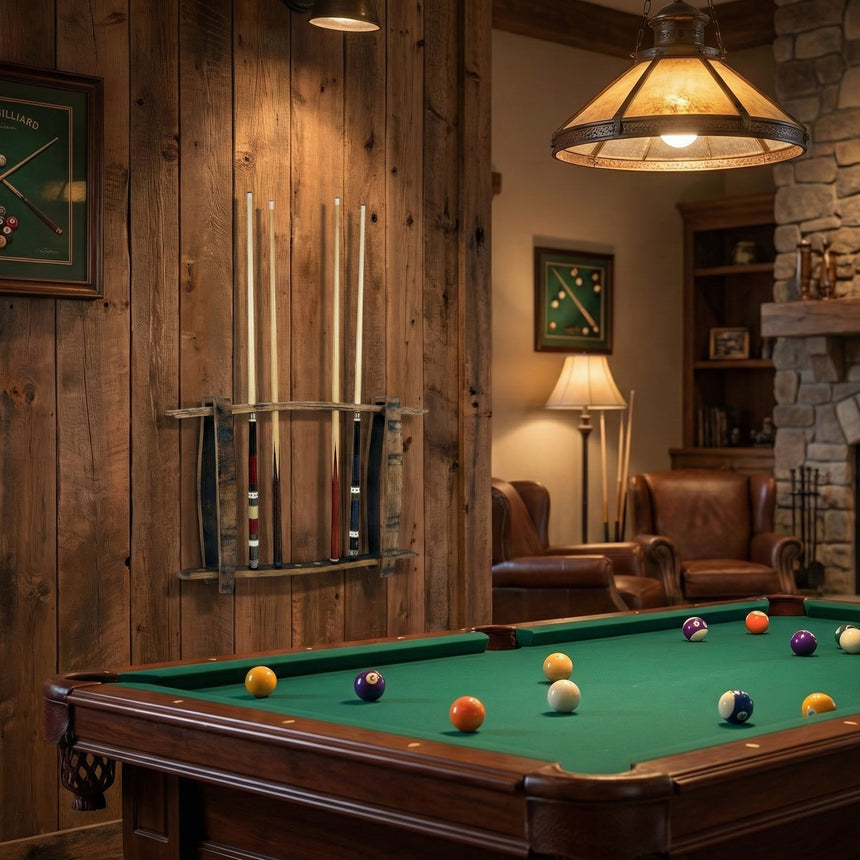 A cozy room with a pool table, freestanding hand-made solid wood barrel stave cue rack holding up to 8 sticks, leather chairs, and a stone fireplace.