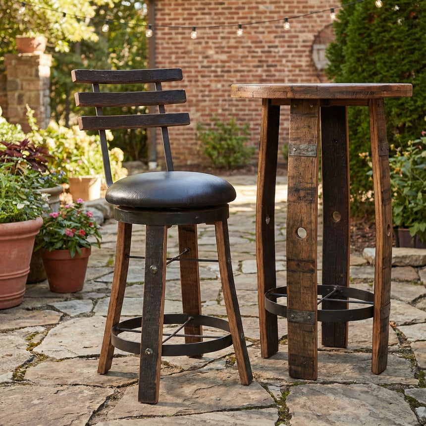 A rustic wooden bar table set on a stone patio with potted plants and a brick wall, featuring the Reverse Leg Stool for added character.