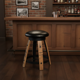 A Bar Stool Cushioned Seat Without Back with a black seat sits in front of a wooden bar counter, enhancing the cozy, rustic charm of the bar setting.