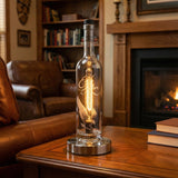 The Eagle Rare Lamp, crafted from a bourbon bottle, sits on a wooden table in a cozy living room and brings vintage charm to the decor.