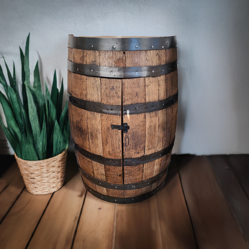 The Half Barrel Cabinet with Door and Shelves, a handmade solid wood mini bar, brings rustic elegance beside a potted plant on the wooden floor.