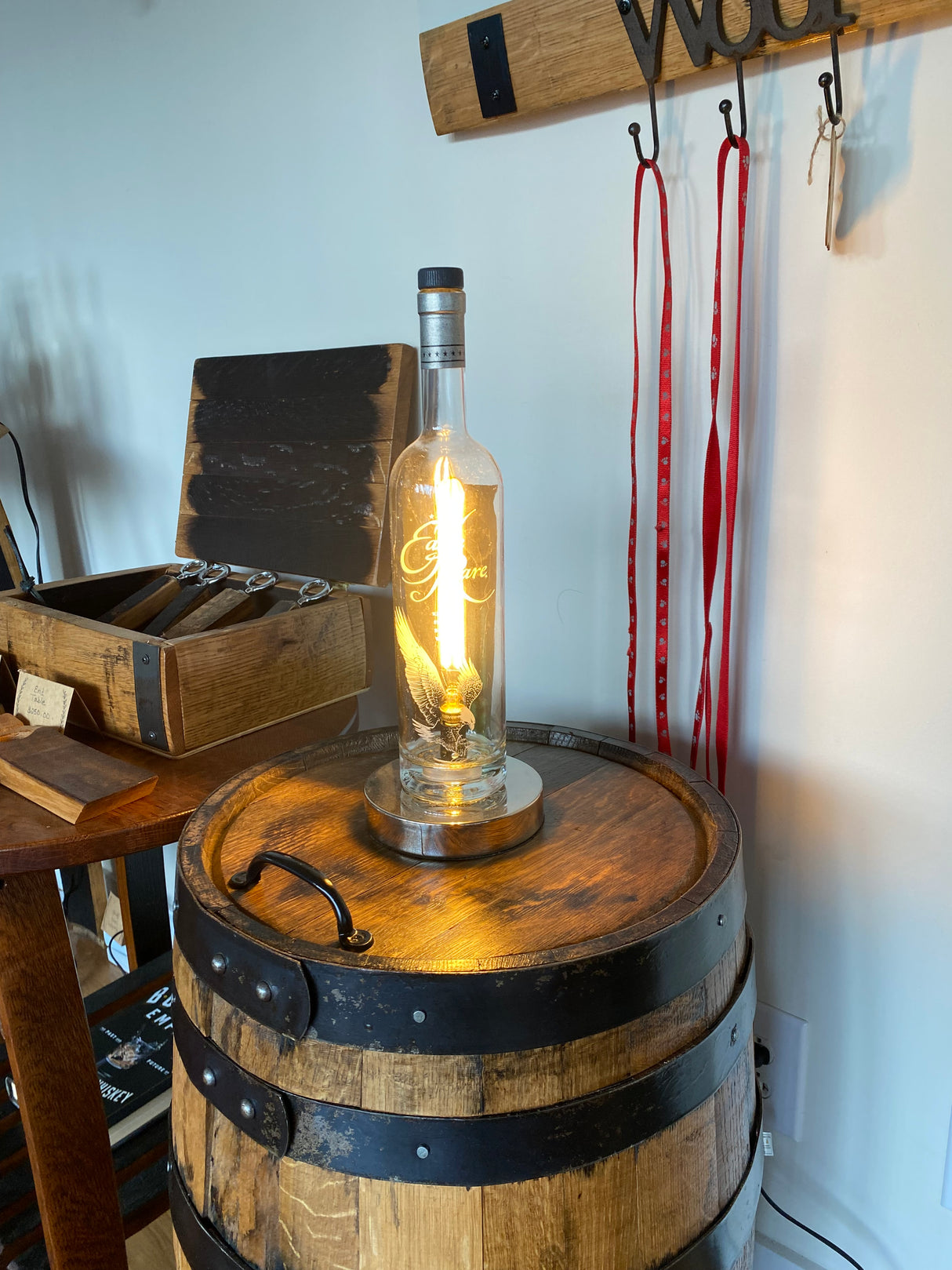 Eagle Rare Lamp displayed on a wooden barrel with rustic decor and tools in the background, highlighting its charming vintage design.