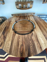 A wooden circular Jack Daniels Pub Table, priced at $1375.00, features a central Jack Daniel's Tennessee Whiskey barrel design with a burnt hickory finish and bottle holders in the background. The table also boasts a glass insert top for added elegance.