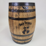 A Standard Refurbished Whiskey Barrel - U003, priced at $350.00, showcases rustic elegance with black metal bands and the Jack Daniel's logo engraved on it, standing as a testament to whiskey-making history.