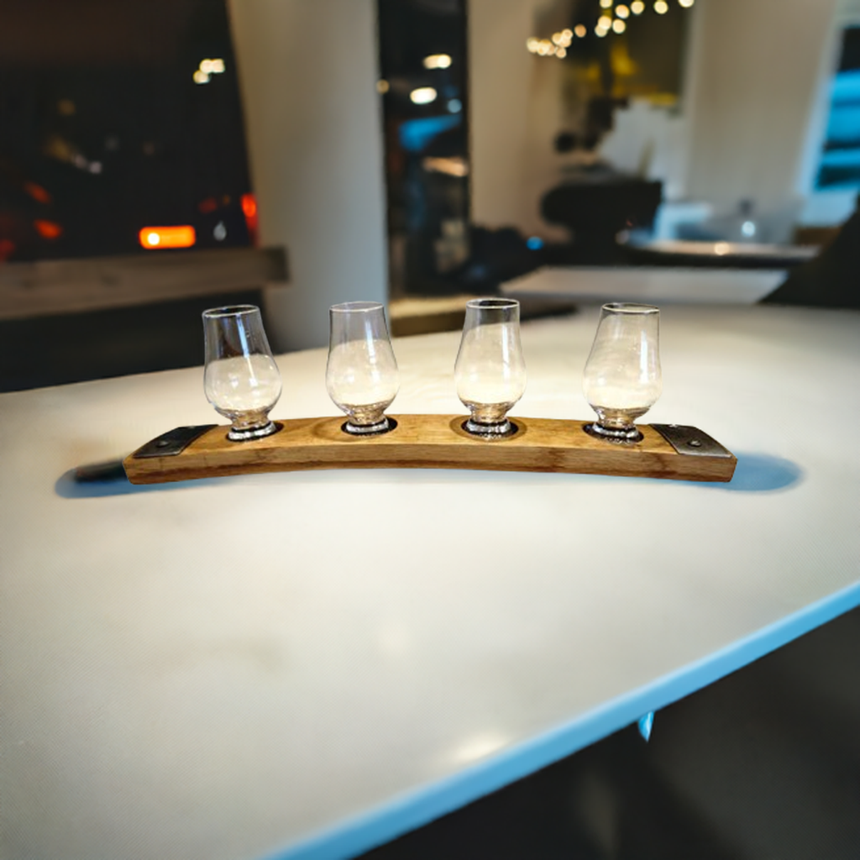 Four empty glasses sit on the Whiskey Tasting Flight Board for 4 Glasses, featuring hand made solid wood construction, displayed on a white table in a modern bar that combines contemporary style with rustic charm.