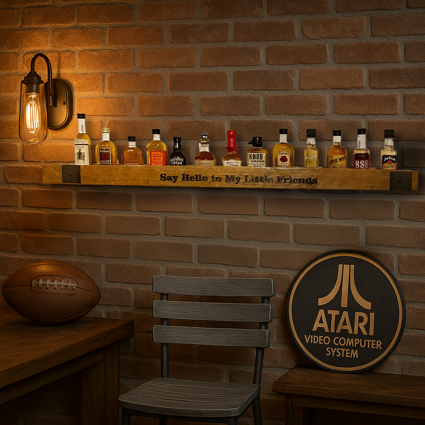 The Whiskey Barrel Stave Shelf for Nippers, holding liquor bottles, brings rustic elegance to a brick wall beside an Atari sign, football, chair, and wall lamp.