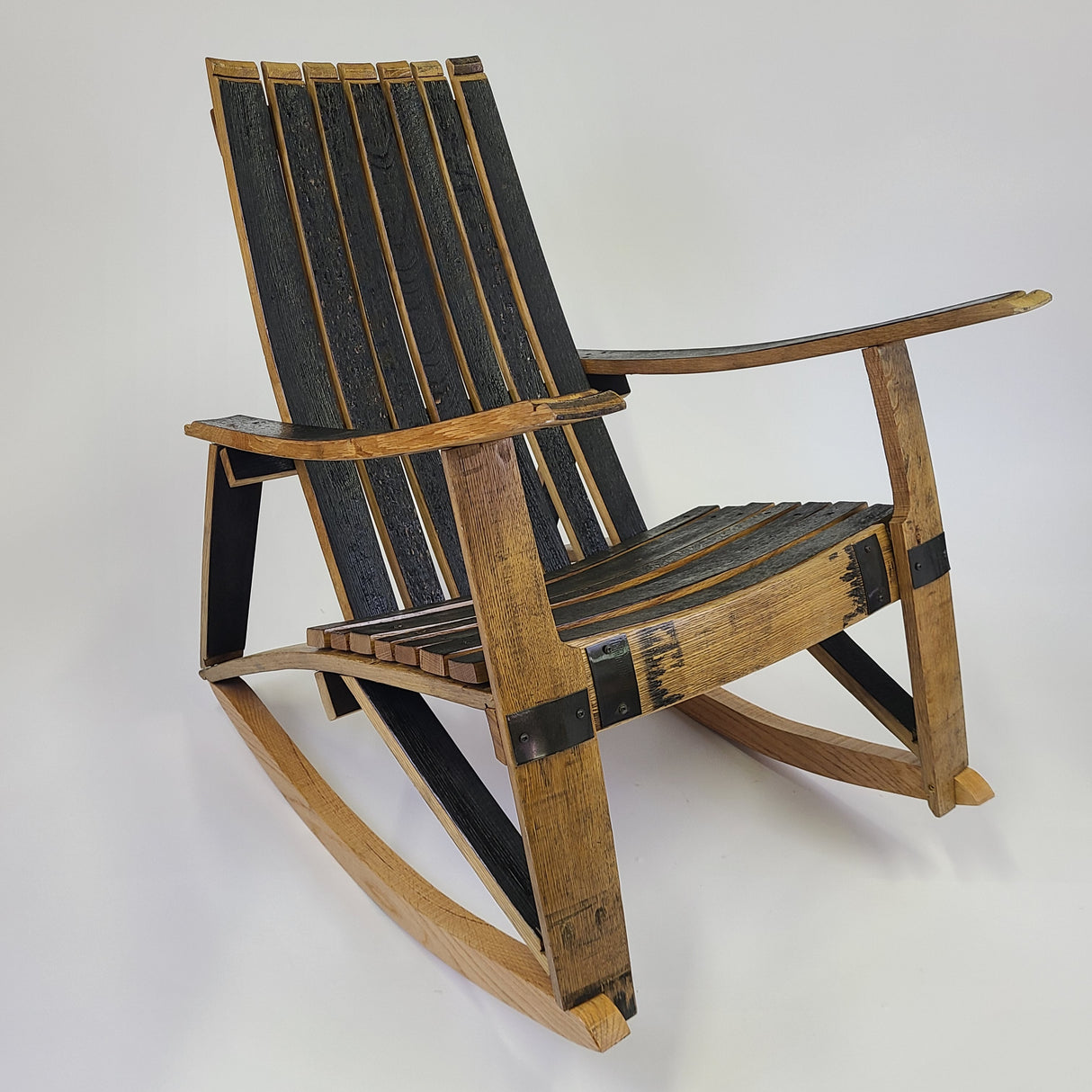 Introducing the Whiskey Barrel Stave Adirondack Chair Rocker - S002, a rustic wooden rocking chair crafted from reclaimed whiskey barrels featuring black and natural wood slats and armrests, set against a plain background. Available for $395.00.