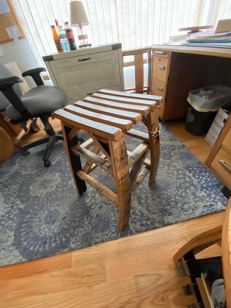 Whiskey Barrel Stave Stool with a slatted seat, priced at $175.00, placed in an office featuring a rug, desks, and various office supplies.