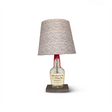 The Maker's Mark Lamp is a unique home decor piece with a Maker's Mark whiskey bottle as its base, a textured fabric shade, and a wooden foundation—perfect for bourbon enthusiasts seeking to add elegance to their space.