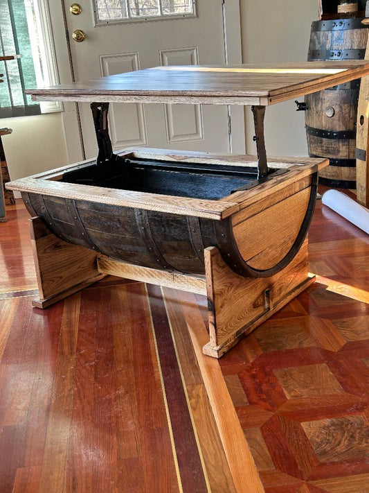 A Whiskey Half Barrel Coffee Table with Lift Top, featuring a burnt hickory top and priced at $935.00, sits elegantly on wooden flooring, with a door subtly positioned in the background.